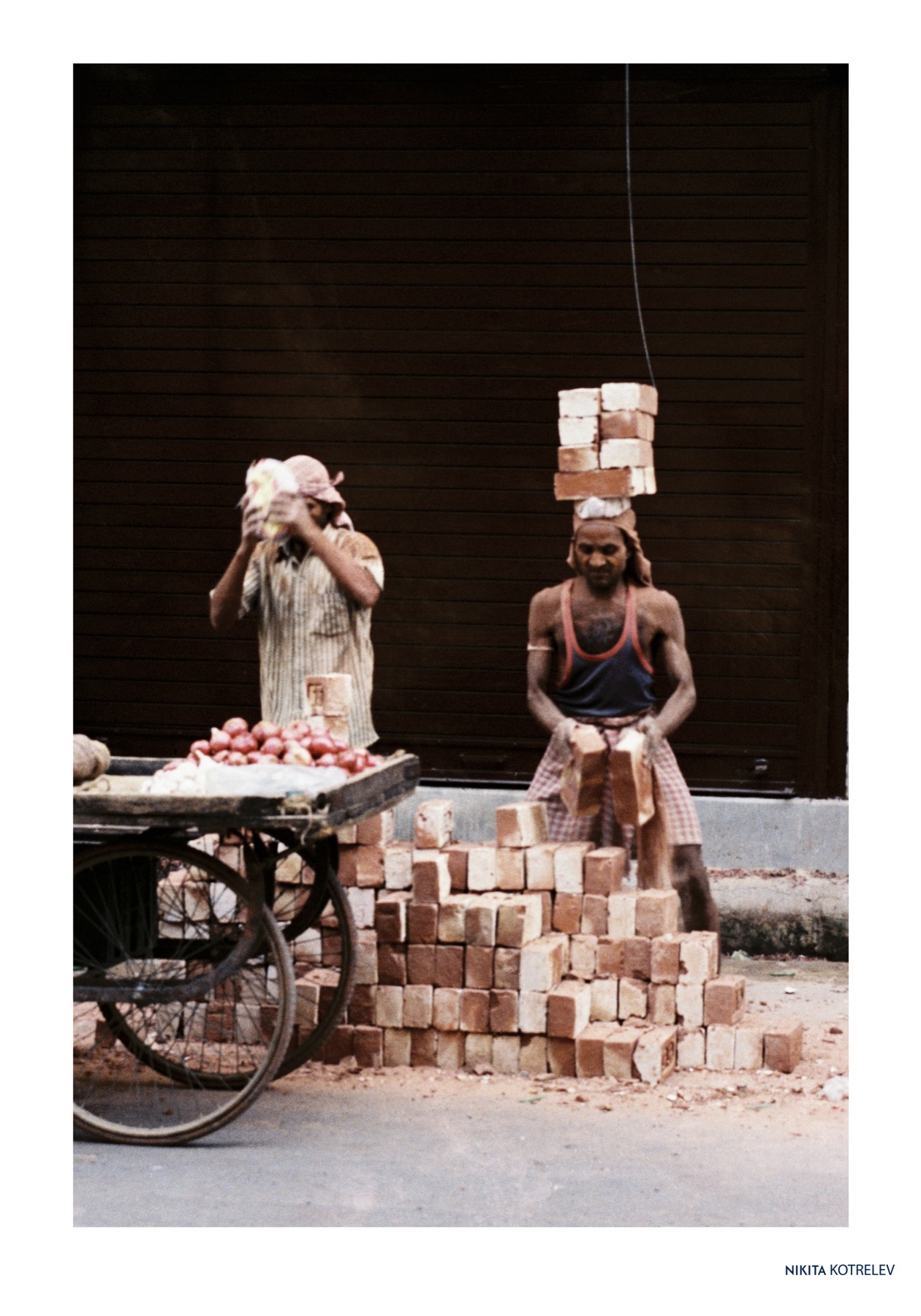 Builders balancing bricks on their heads. Varanasi, India, 2026